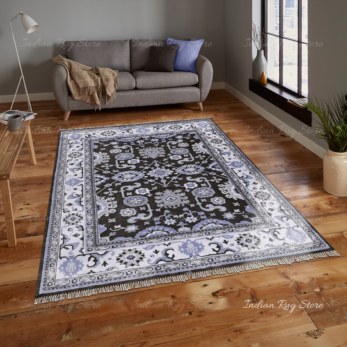 A cozy living room with an Oushak rug, a sofa, and soft lighting.